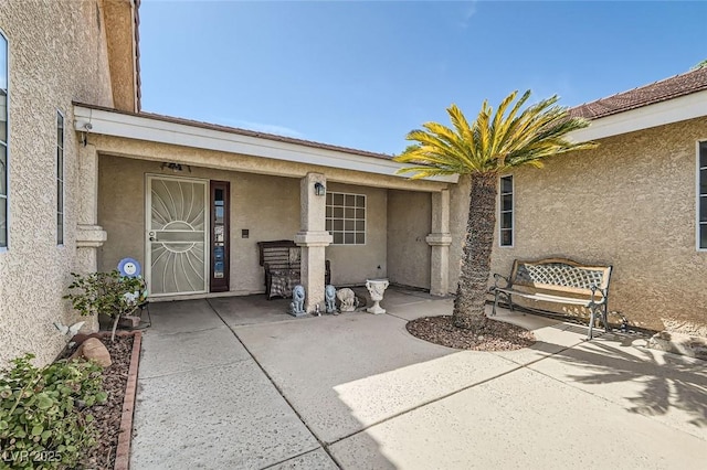 view of exterior entry with stucco siding