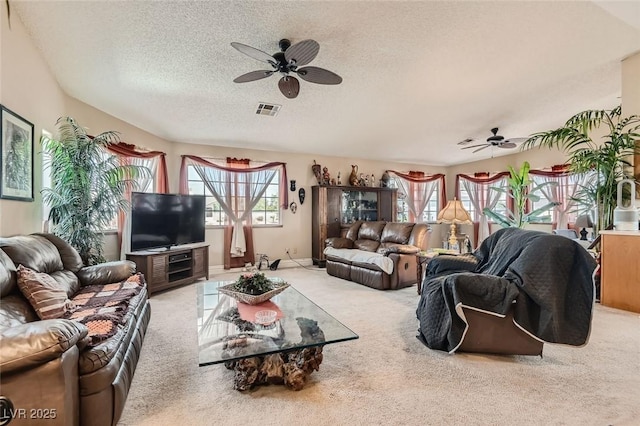 living room with a ceiling fan, a textured ceiling, visible vents, and carpet flooring