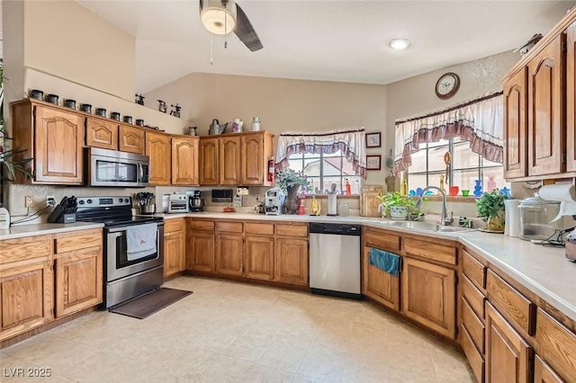 kitchen with brown cabinetry, appliances with stainless steel finishes, light countertops, and a sink