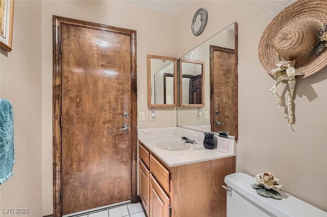 bathroom with toilet, tile patterned floors, and vanity