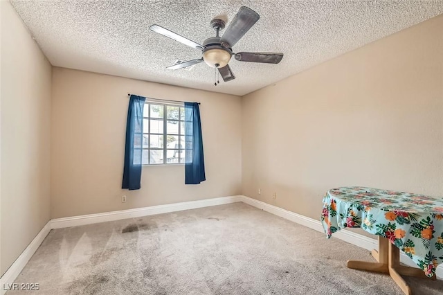 unfurnished bedroom with ceiling fan, a textured ceiling, carpet flooring, and baseboards