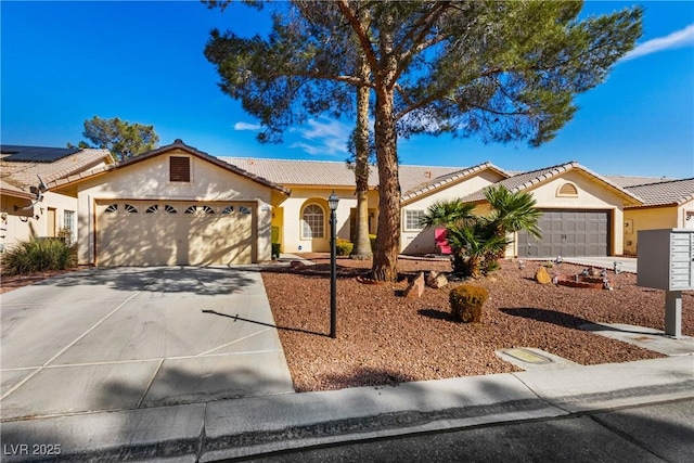 view of front of property featuring a garage, concrete driveway, a tile roof, and stucco siding