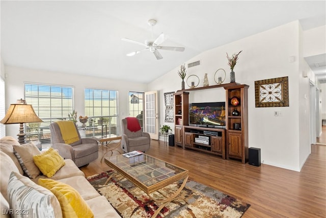 living area featuring a ceiling fan, lofted ceiling, visible vents, and wood finished floors