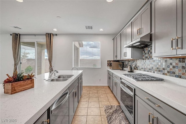 kitchen featuring under cabinet range hood, gray cabinets, visible vents, and stainless steel appliances