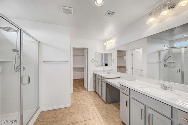 bathroom featuring a shower stall, visible vents, tile patterned flooring, and vanity