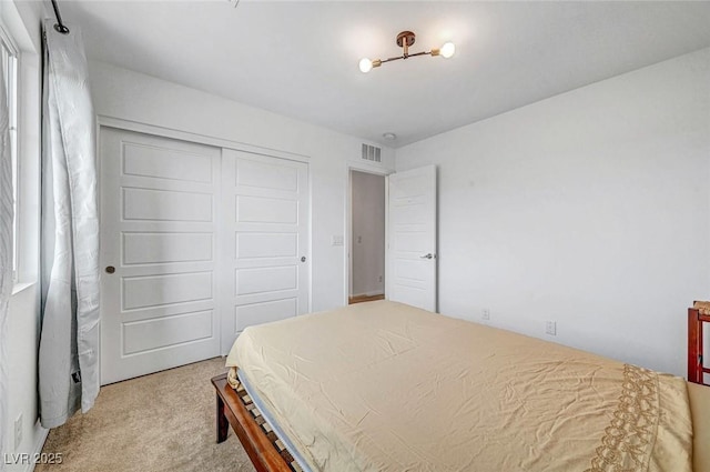 bedroom with a closet, carpet flooring, and visible vents