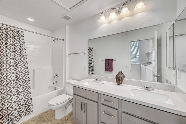 bathroom featuring toilet, independent washer and dryer, a sink, and visible vents