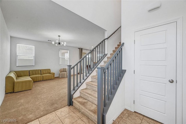 stairway with tile patterned flooring, carpet, baseboards, and a notable chandelier