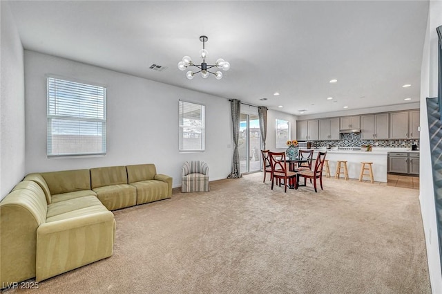 living area with light carpet, visible vents, a notable chandelier, and recessed lighting