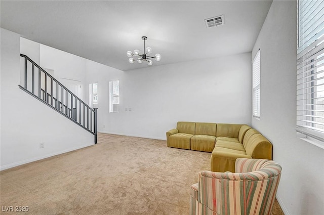 living area featuring a notable chandelier, visible vents, baseboards, stairs, and carpet