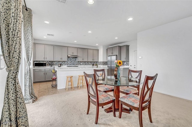 dining room with light tile patterned floors, recessed lighting, and light colored carpet