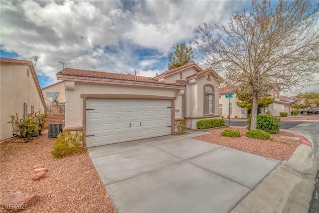 mediterranean / spanish-style home featuring stucco siding, concrete driveway, a garage, cooling unit, and a tiled roof