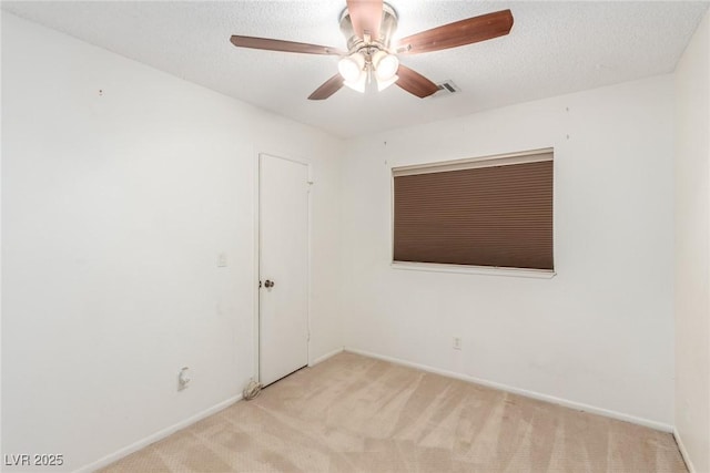 unfurnished room featuring carpet floors, a ceiling fan, visible vents, and baseboards