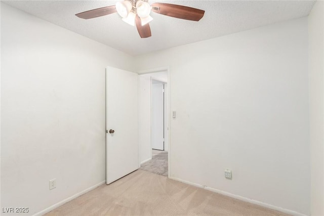 empty room featuring ceiling fan, baseboards, and light carpet