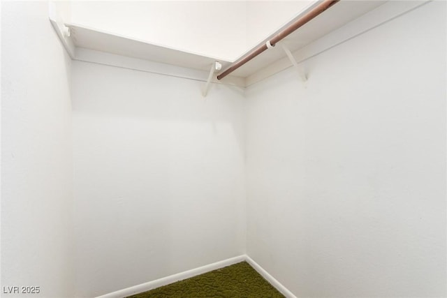 spacious closet featuring dark colored carpet