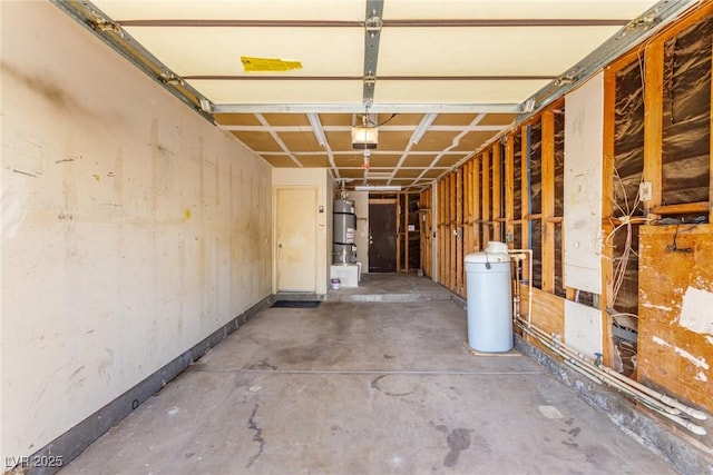 garage with a garage door opener, baseboards, and strapped water heater