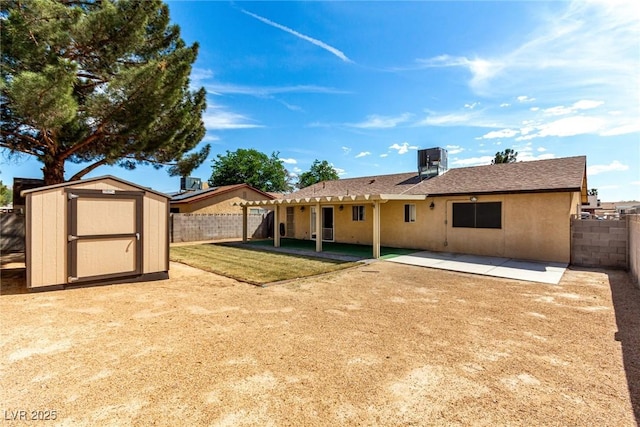 back of property with a patio area, a fenced backyard, a storage unit, and an outbuilding