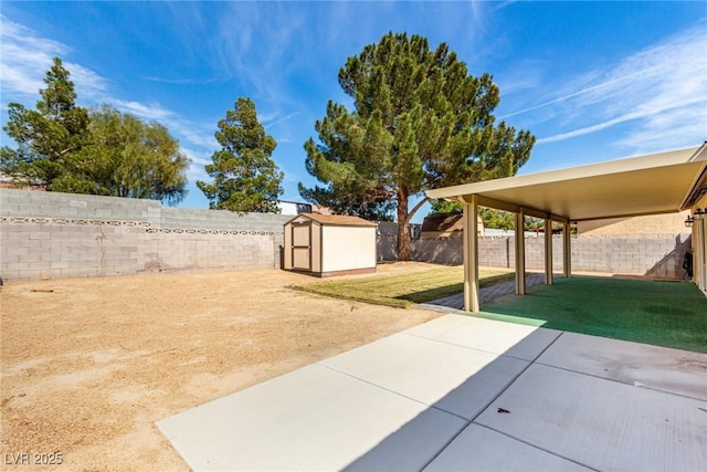 view of yard with a storage shed, a patio area, a fenced backyard, and an outdoor structure