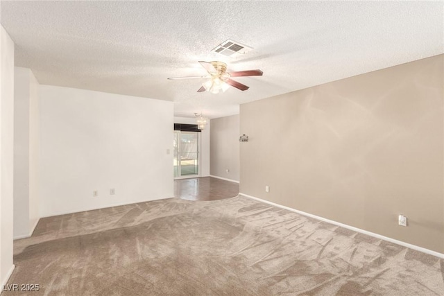 carpeted spare room with ceiling fan, a textured ceiling, and visible vents
