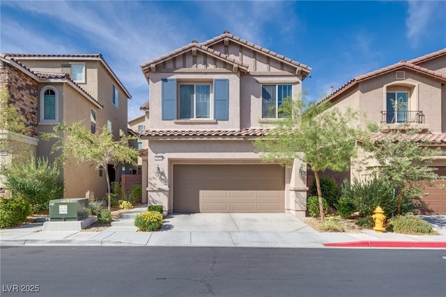 view of front of property with driveway, a tiled roof, an attached garage, and stucco siding