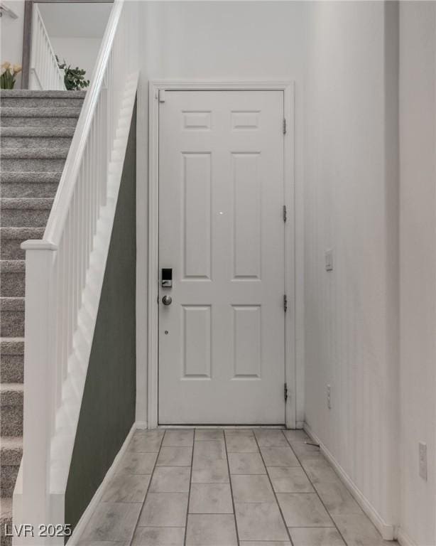 exterior space with stairs, baseboards, and light tile patterned floors