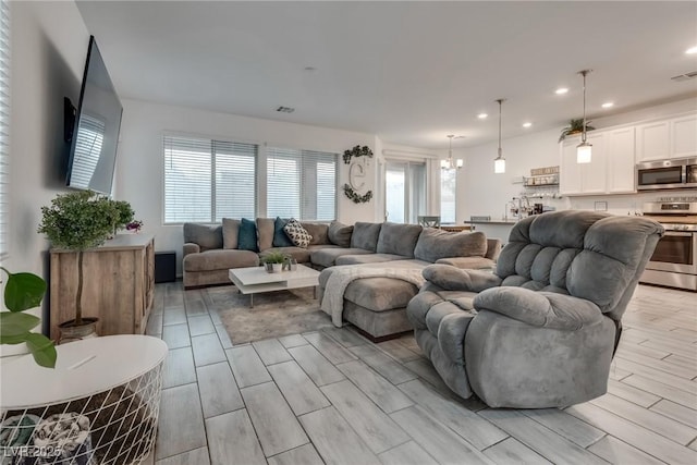 living area featuring visible vents, recessed lighting, a wealth of natural light, and wood tiled floor