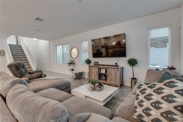 living area featuring visible vents and stairs