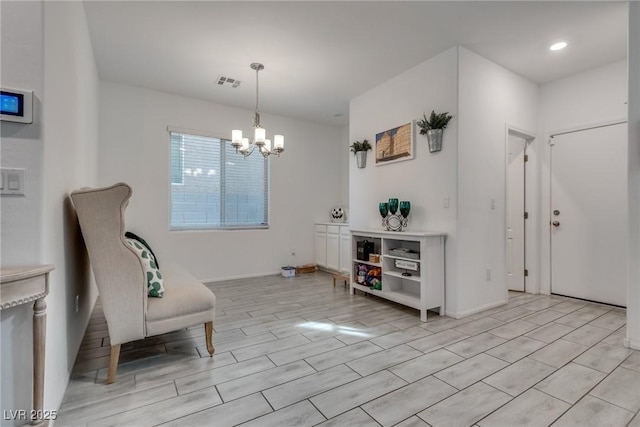 living area with visible vents, a chandelier, and wood finish floors