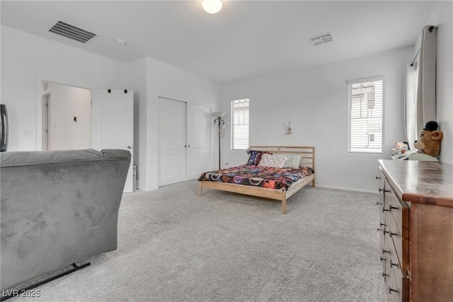 carpeted bedroom with a closet and visible vents