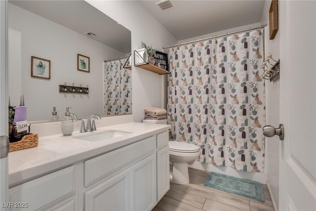 full bathroom featuring toilet, a shower with shower curtain, vanity, and visible vents