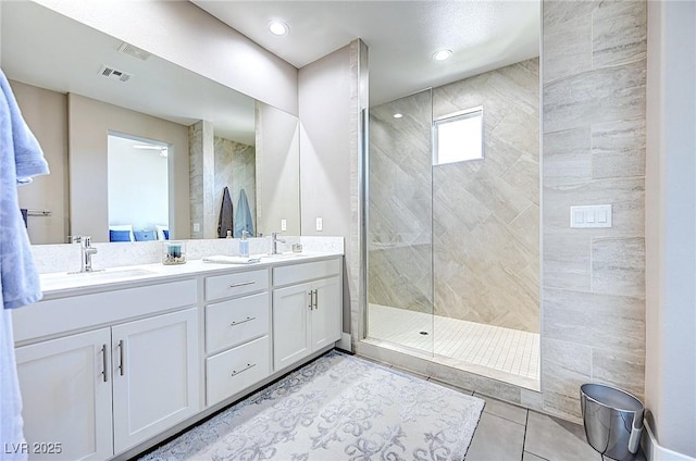 bathroom with tile patterned flooring, visible vents, a sink, and a walk in shower