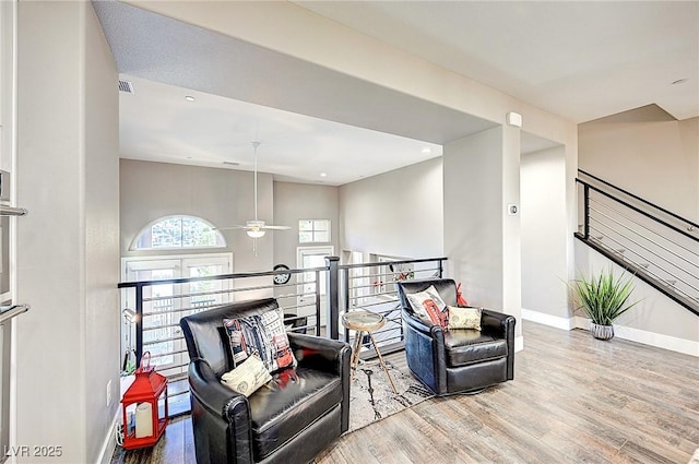 sitting room featuring a ceiling fan, baseboards, and wood finished floors