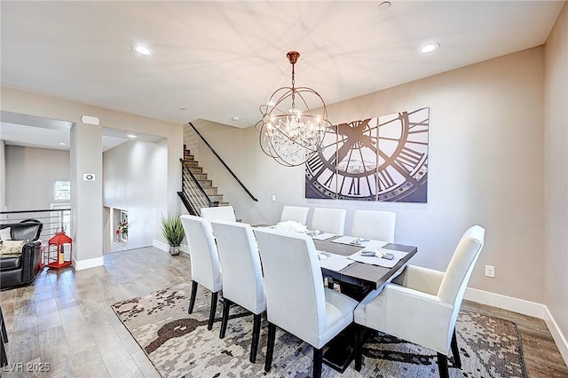 dining area featuring an inviting chandelier, baseboards, and wood finished floors