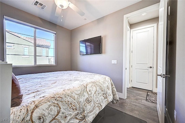 bedroom featuring a ceiling fan, baseboards, visible vents, and dark wood-type flooring