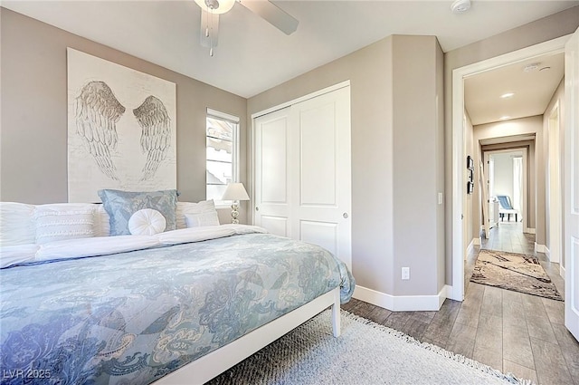 bedroom with a ceiling fan, a closet, baseboards, and wood finished floors