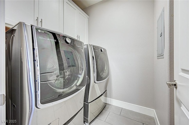 laundry room featuring cabinet space, light tile patterned floors, baseboards, and independent washer and dryer