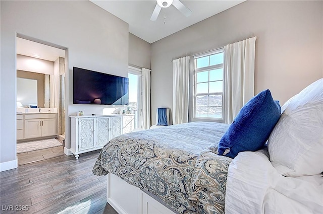 bedroom with ceiling fan, ensuite bath, wood finished floors, and baseboards