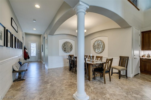 dining room featuring arched walkways, recessed lighting, baseboards, and ornate columns