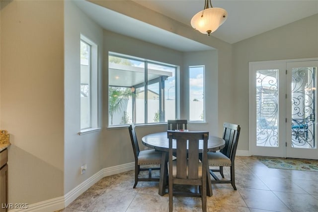 dining space featuring vaulted ceiling, light tile patterned flooring, french doors, and baseboards