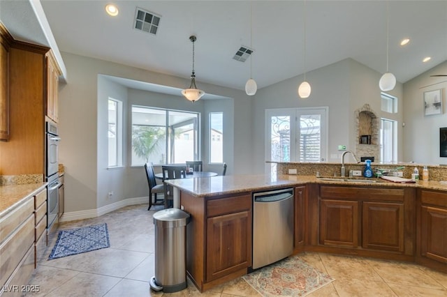 kitchen with visible vents, a sink, appliances with stainless steel finishes, brown cabinets, and a wealth of natural light