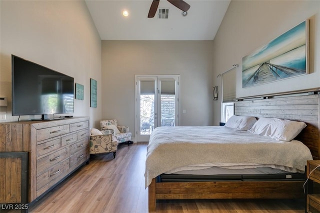 bedroom with visible vents, high vaulted ceiling, a ceiling fan, and wood finished floors