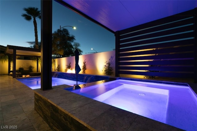 outdoor pool featuring an in ground hot tub and a patio area