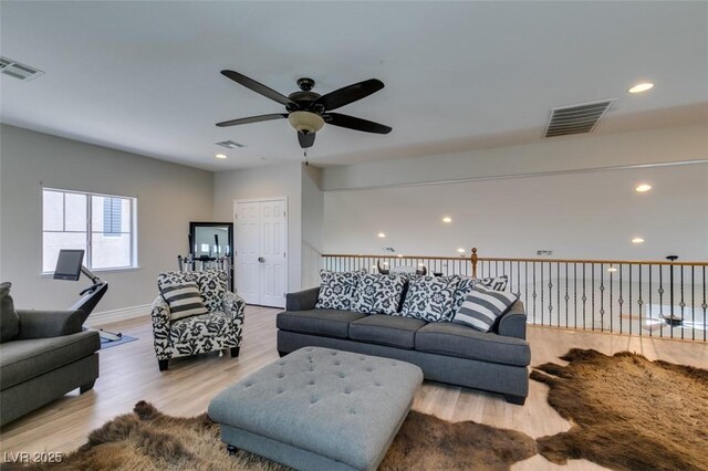 living area with visible vents, recessed lighting, and wood finished floors