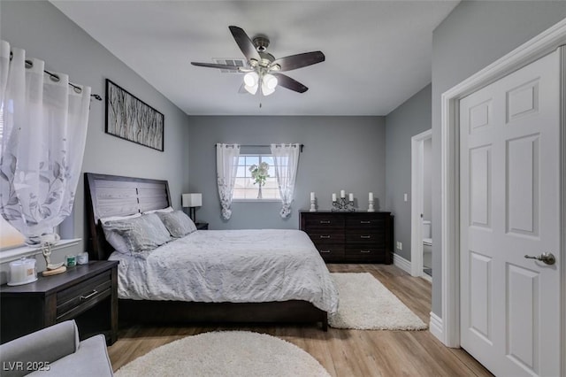 bedroom featuring visible vents, baseboards, light wood finished floors, and ceiling fan