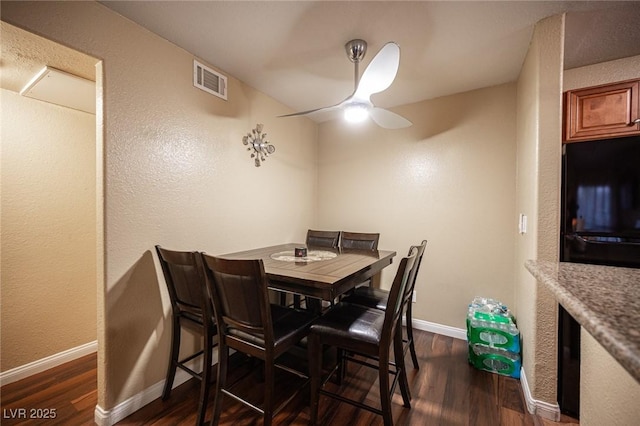 dining room with baseboards, visible vents, ceiling fan, and dark wood-type flooring