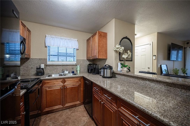 kitchen featuring decorative backsplash, light tile patterned flooring, a sink, a textured ceiling, and black appliances