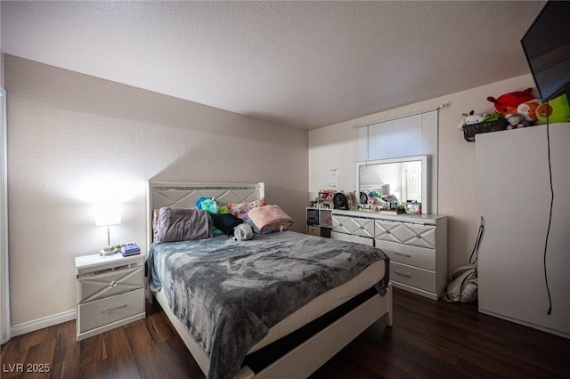 bedroom featuring a textured wall, dark wood finished floors, and a textured ceiling