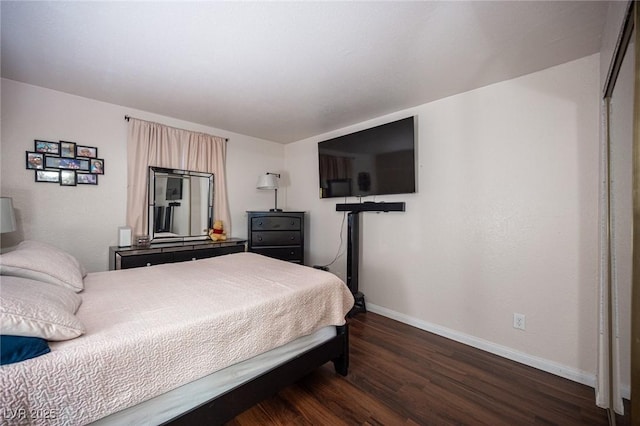 bedroom featuring baseboards and dark wood-style flooring