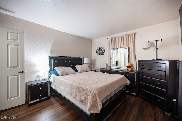 bedroom featuring dark wood-type flooring and a textured wall