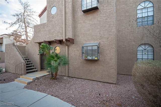 exterior space with stairs and stucco siding